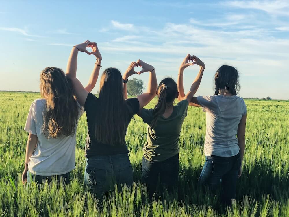 4 friends standing in a garden